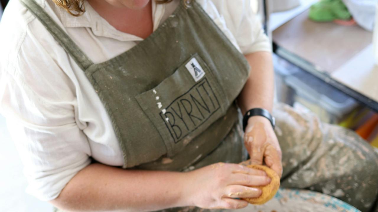 Ruth in her walking apron at the pottery wheel