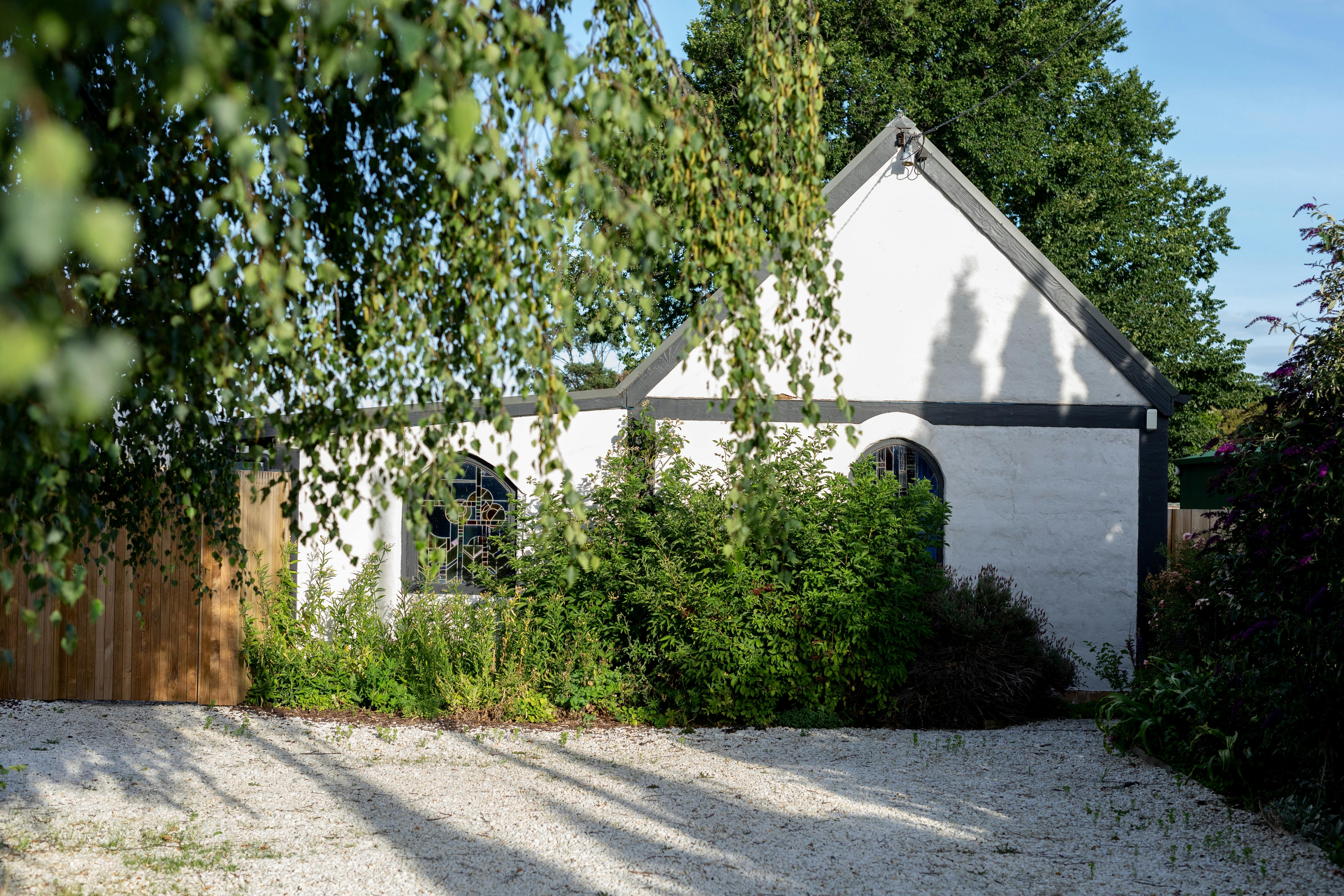 White mudbrick cottage with stained glass windows