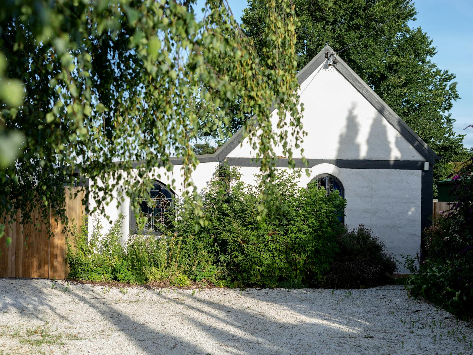 White mudbrick cottage with stained glass windows
