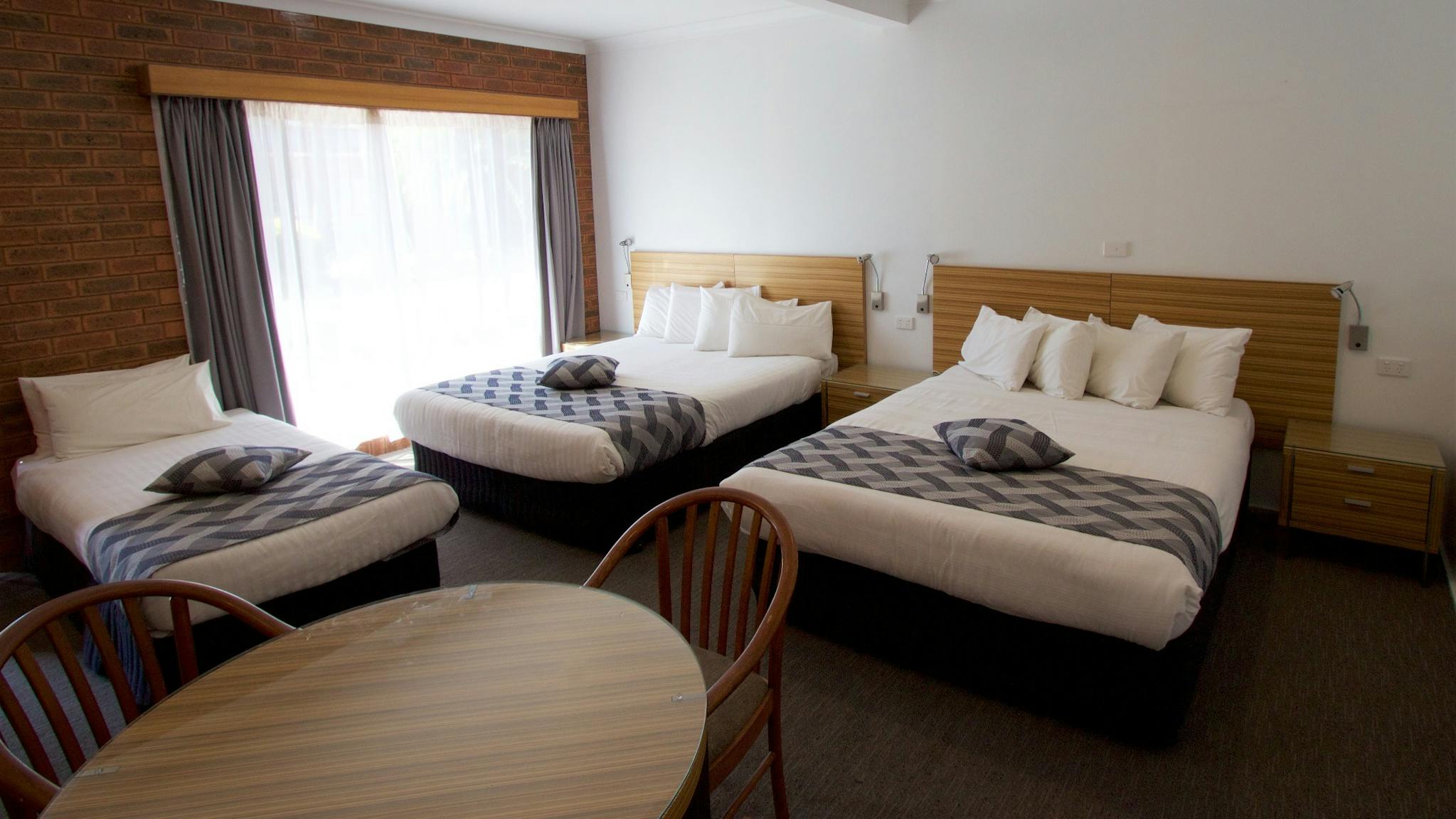 Extra large room with two queen beds and one single bed and separate dining table.