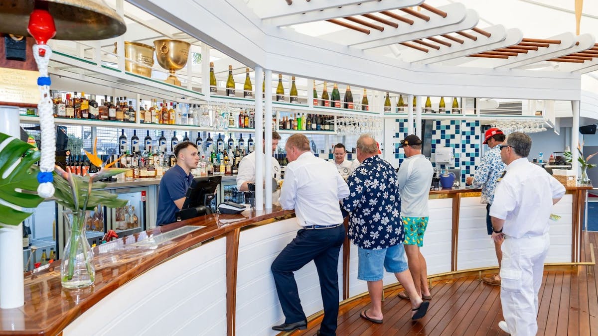 A group of men queueing at a bar