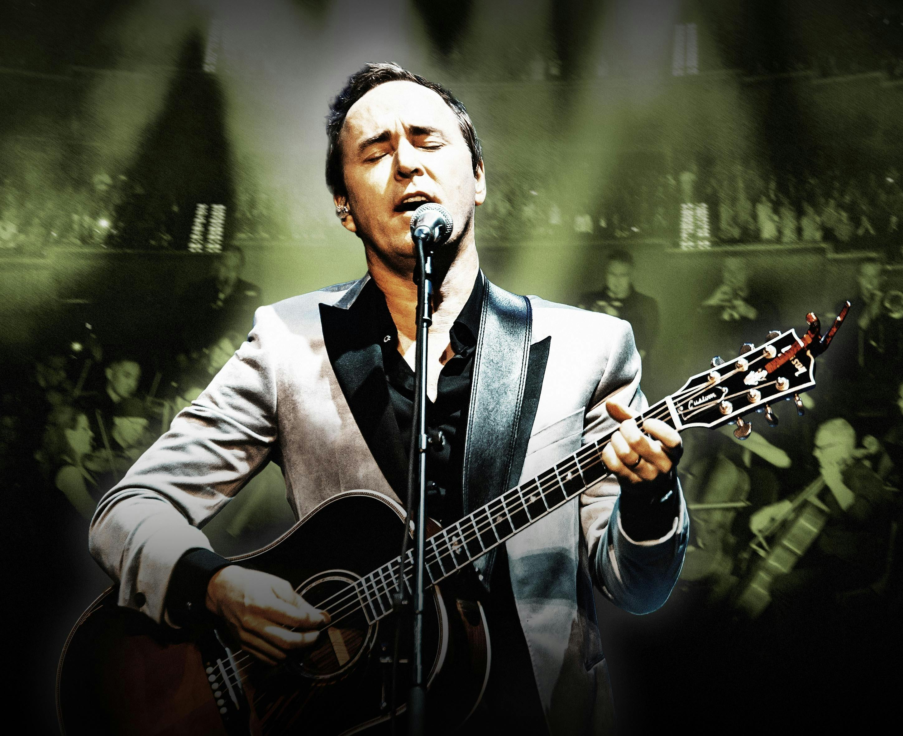 Photo of Damien Leith playing guitar and singing into a microphone.