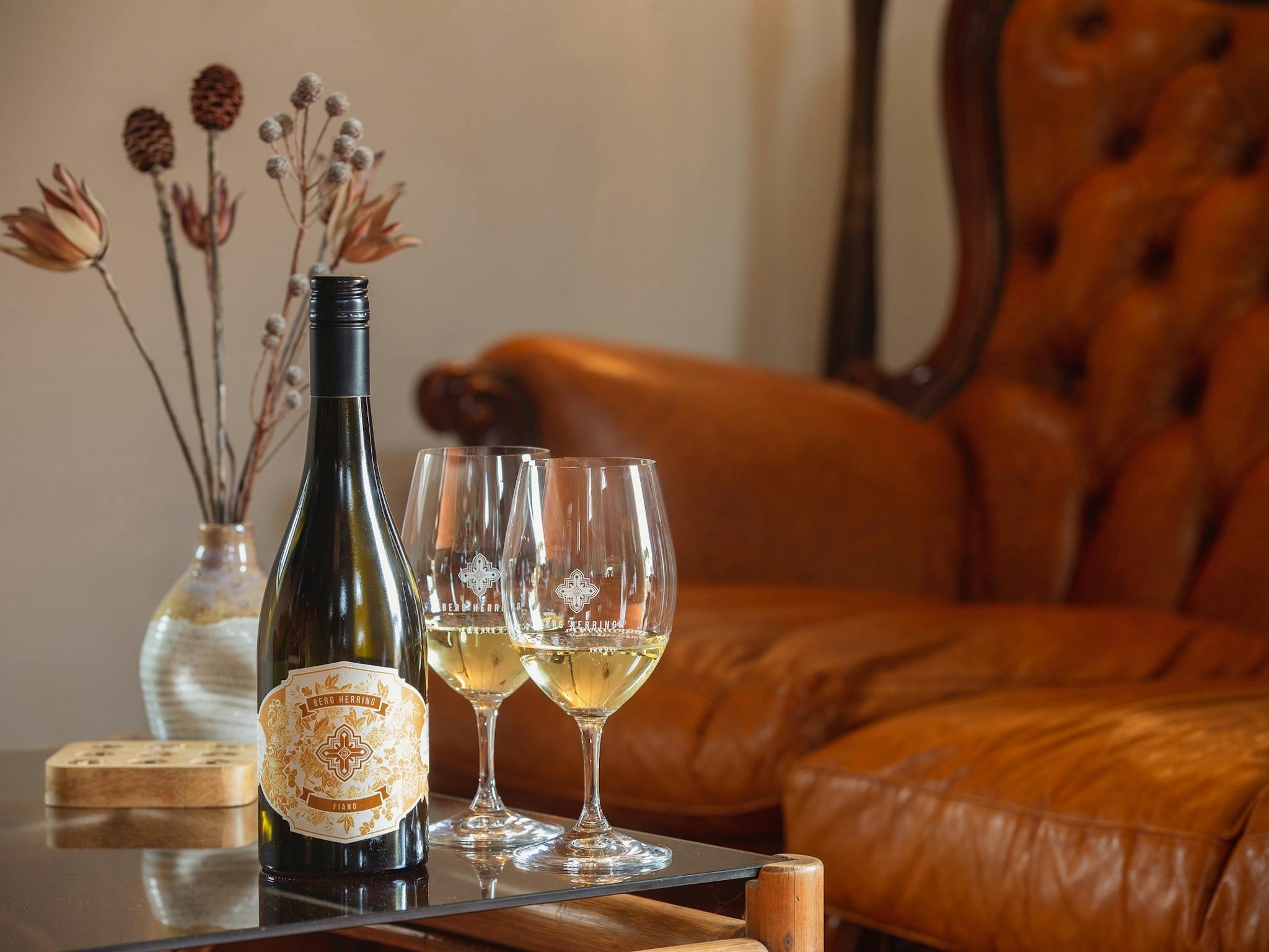 Wine bottle and wine glasses on table in front of antique couch