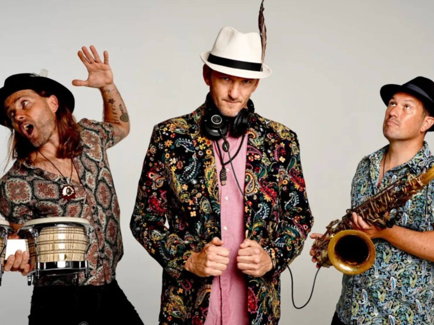 Whole band next too eachother and posing in a white room