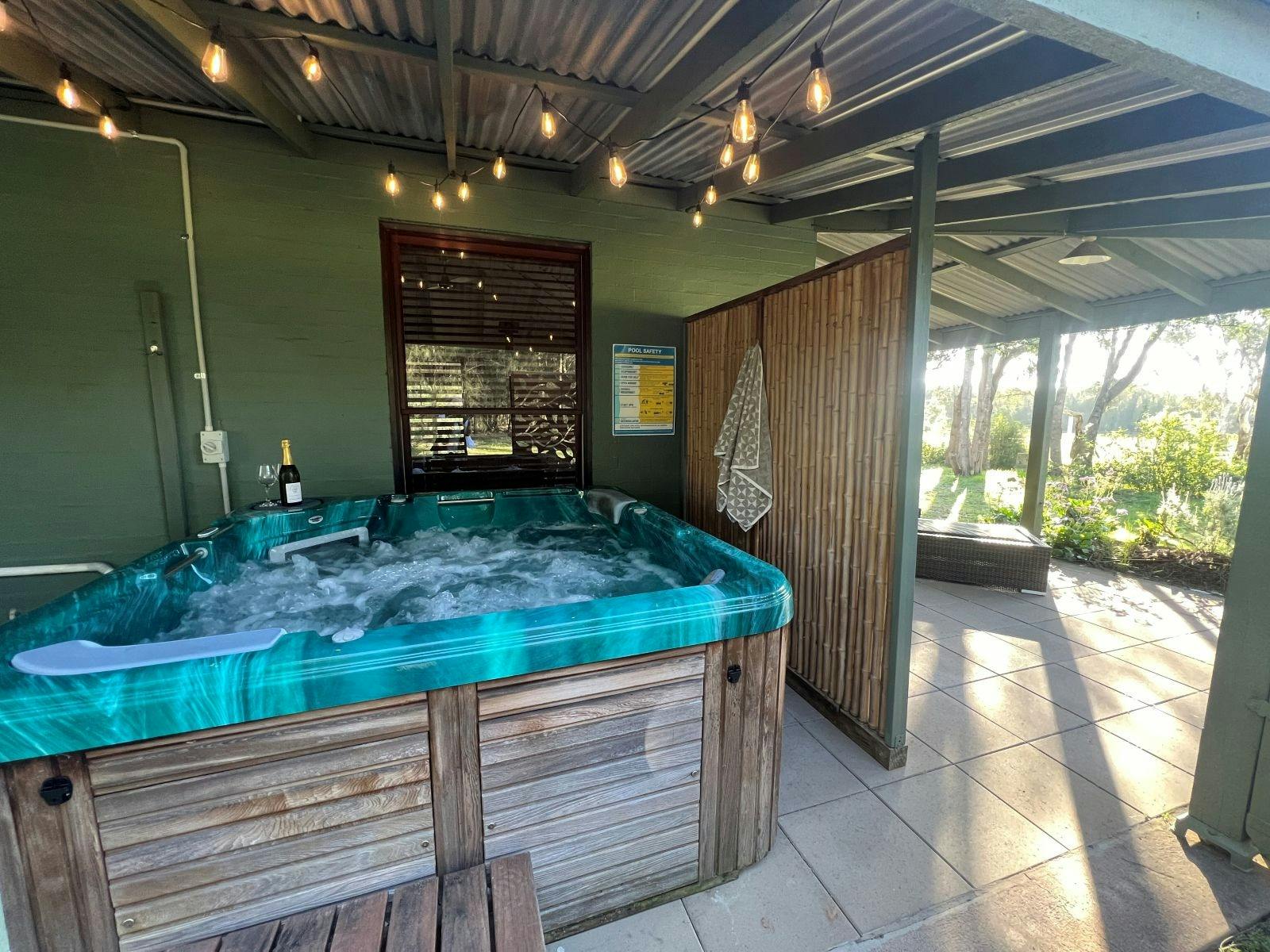 The outdoor hot tub under a canopy of festoon lights at Artist Studio