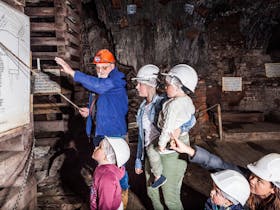 Mine Manager Geoff Anderson showing a family a map of the mine while deep underground