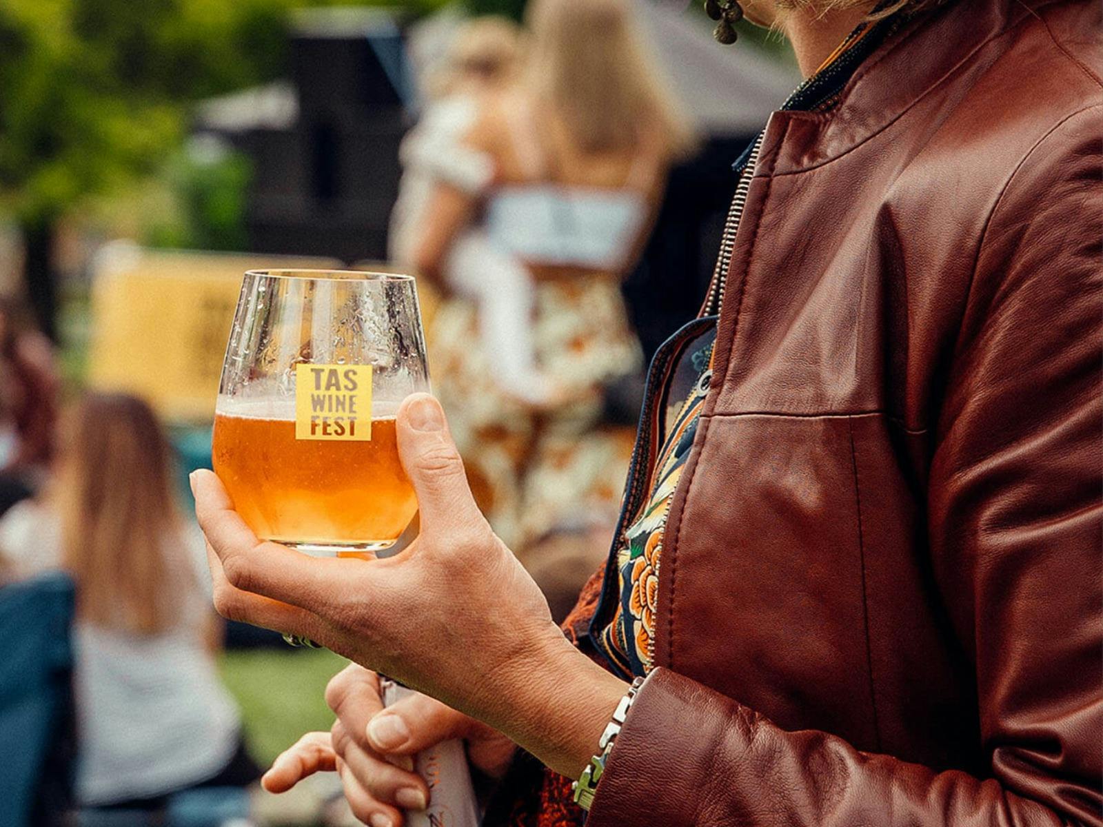 Image of a Tasmanian Wine Festival branded glass, filled with wine