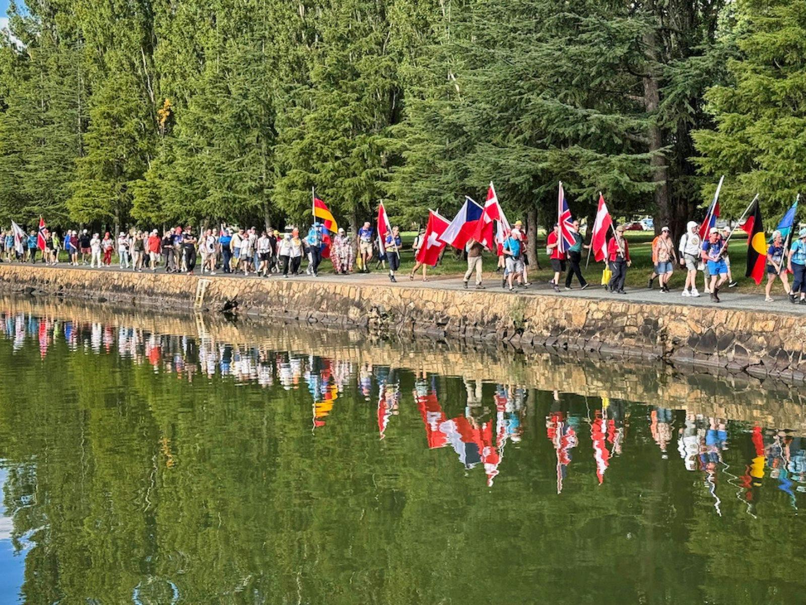 a croud of people walking holding country flags