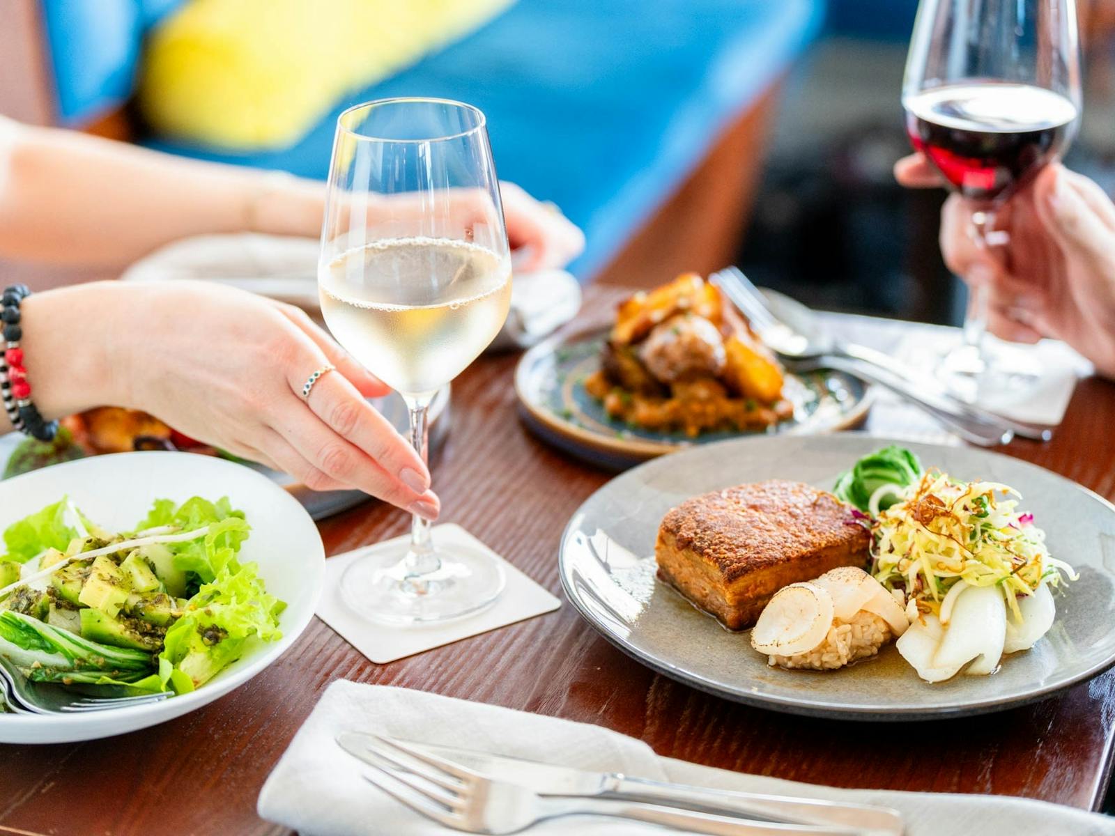 Image of a table with a variety of dishes and wines