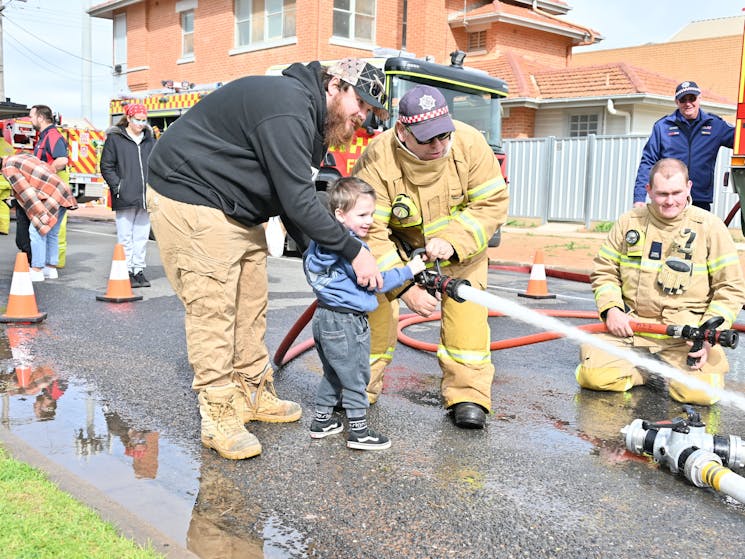 A child having fun with a fire hose