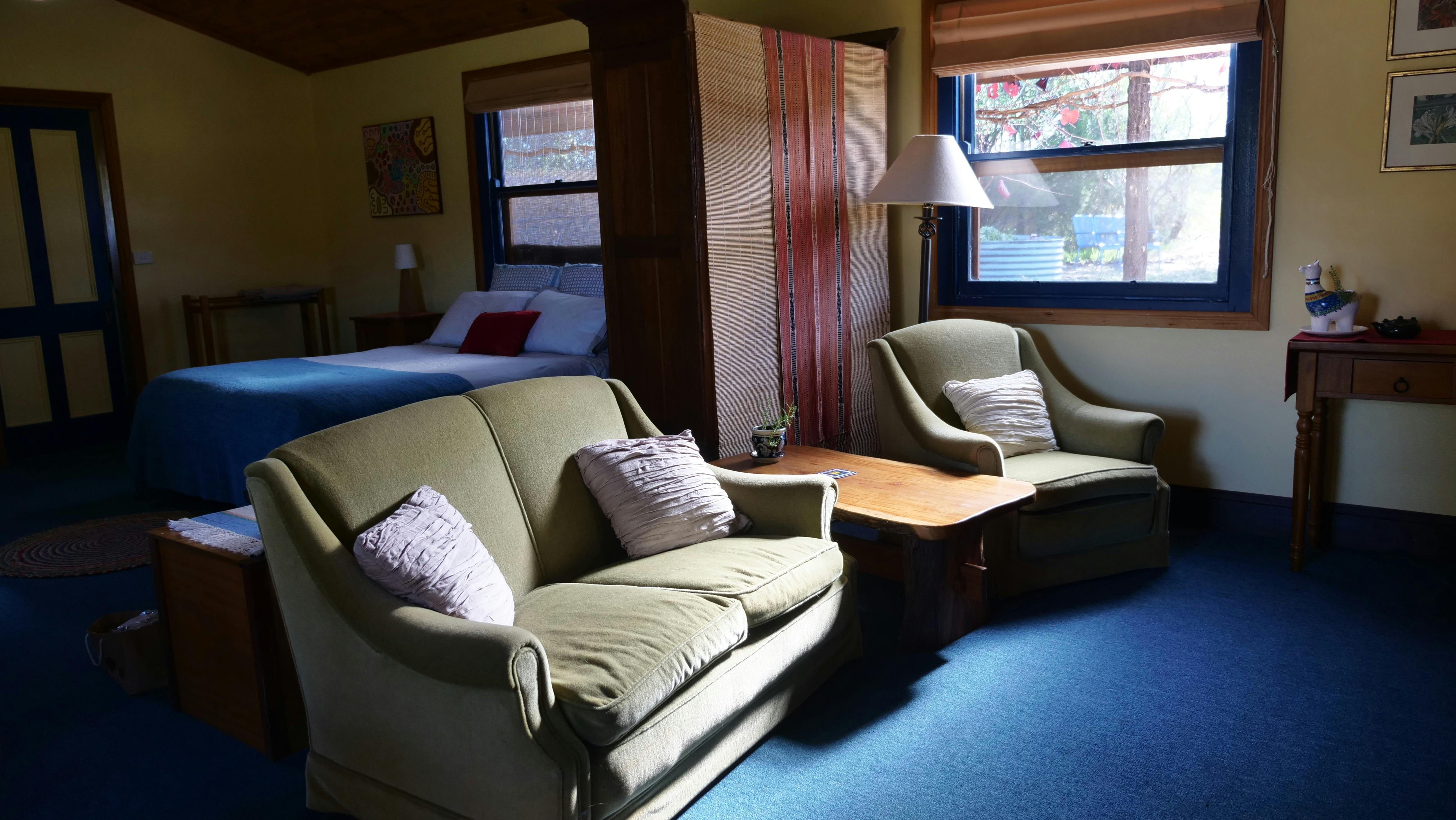 Living area with a sofa, a chair and a coffee table and lamp by the window