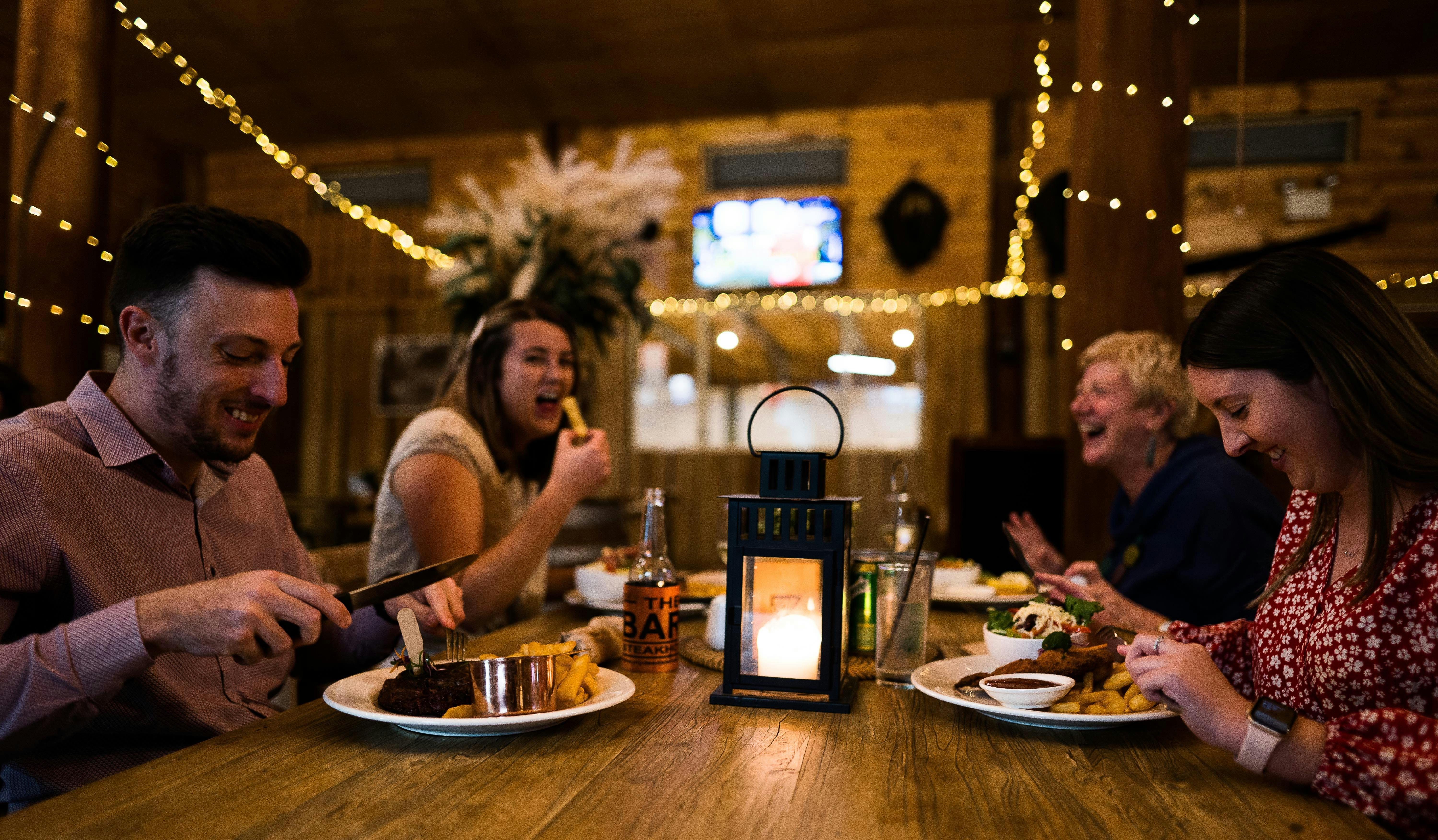 group of adults enjoying their meal and laughing.