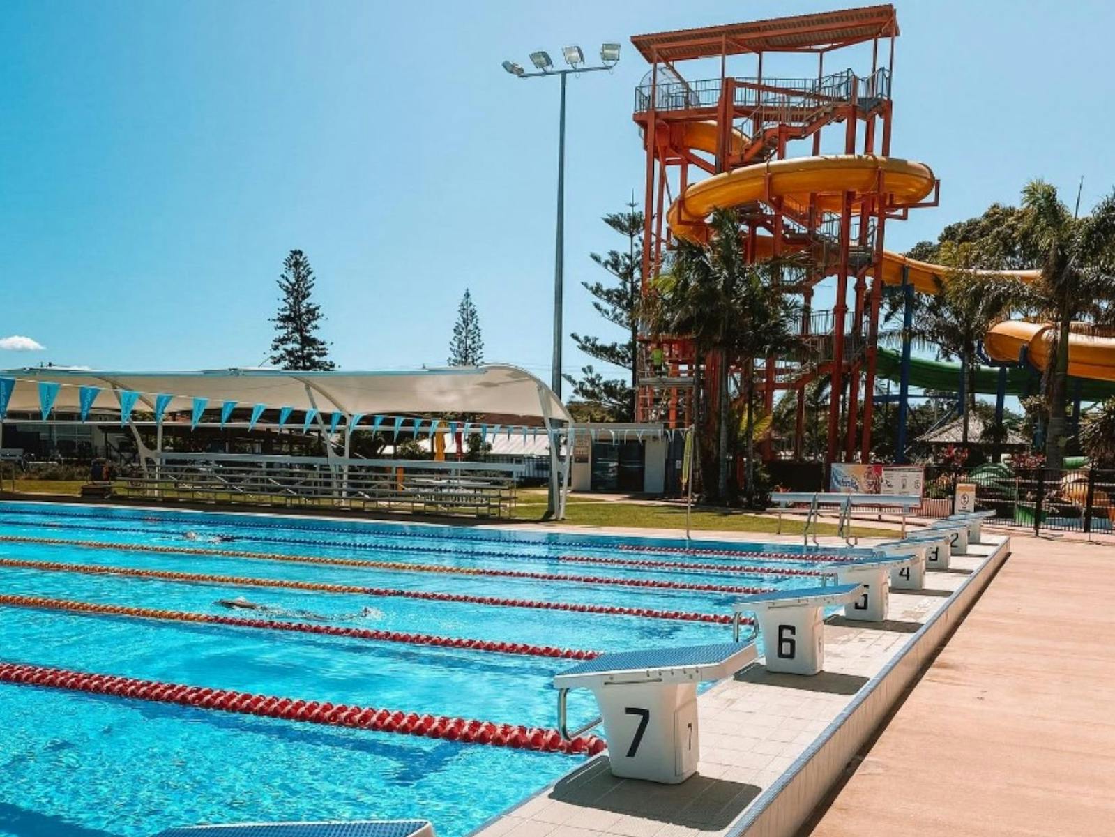 Image of the multi lane pool and waterslides in the background