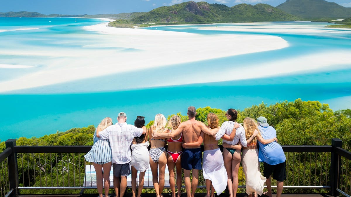 Group of travellers overlooking the swirling sands of Whitehaven Beach from Hill Inlet Lookout