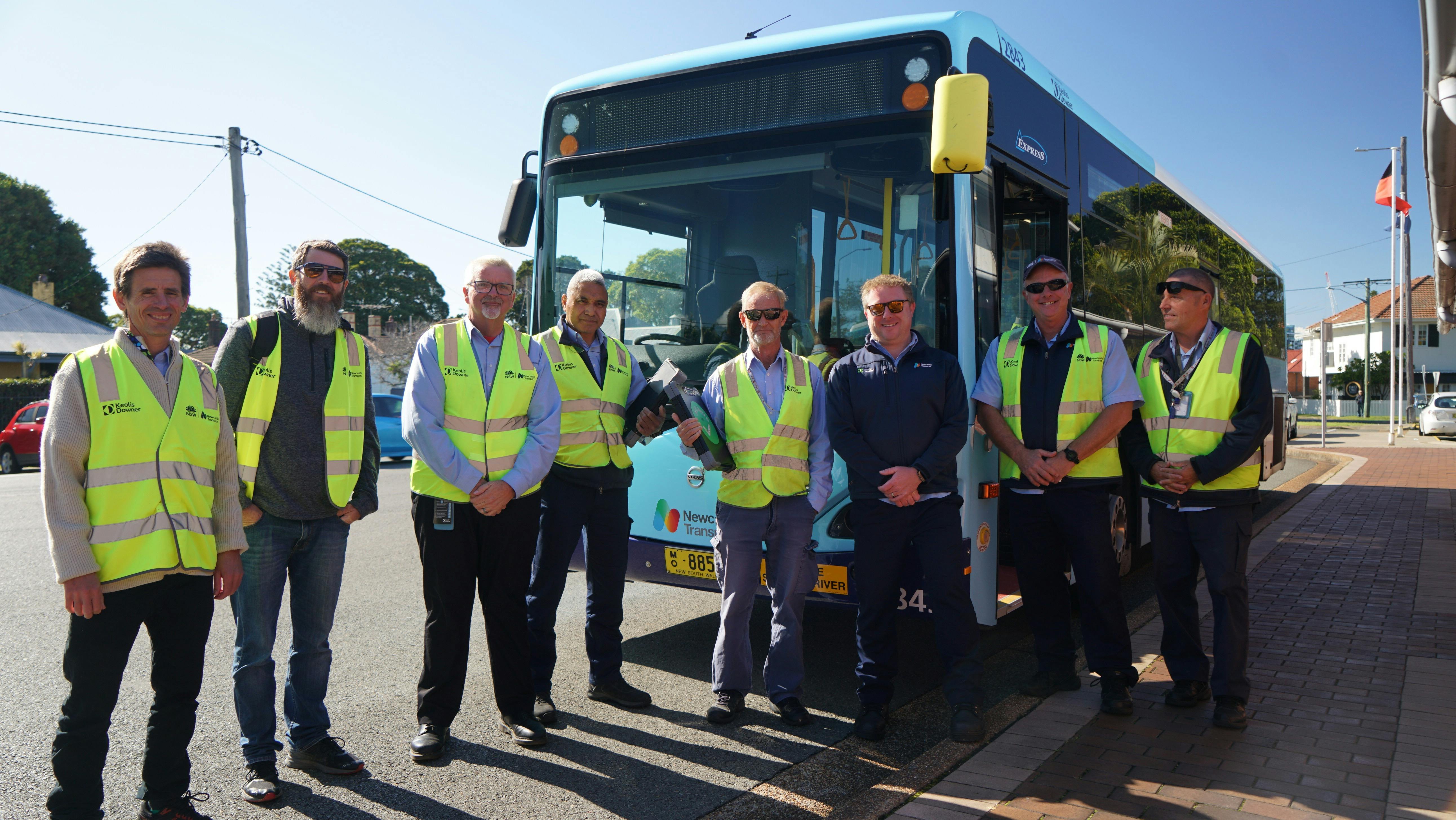 Photo of bus drivers standing in front of a bus