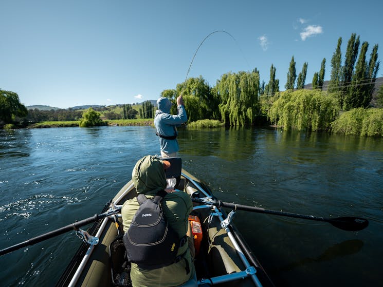 Fly fishing for trout on a drift boat on the Tumut river in the Snowy Mountains