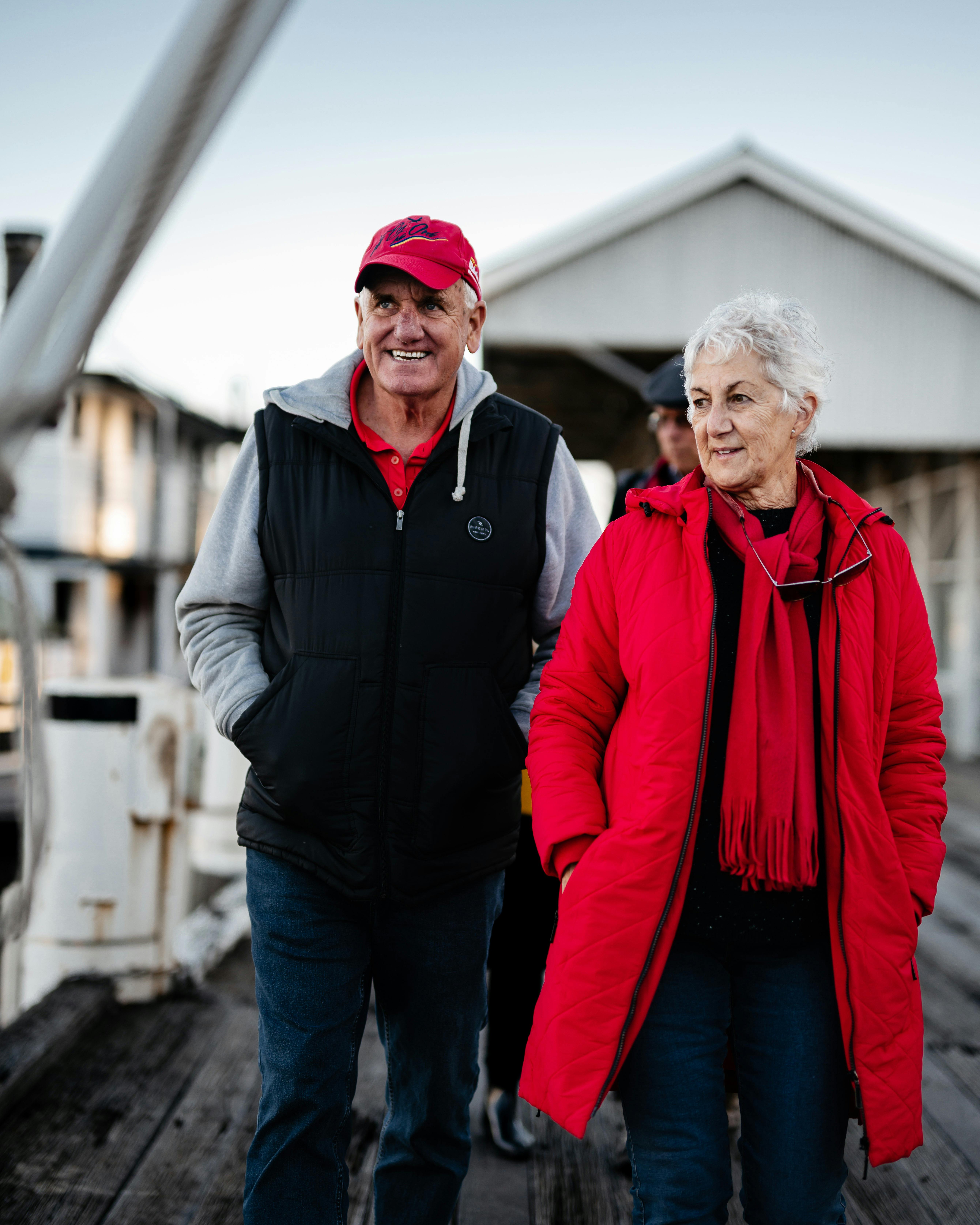 Two people walking the Wharf all rugged up and ready to board