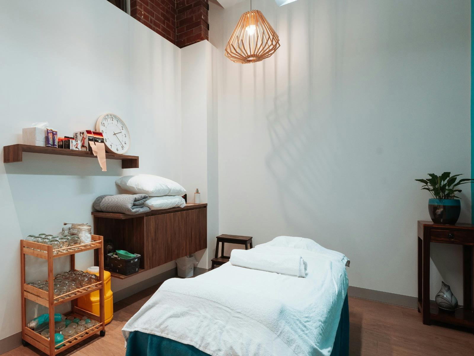 Modern sleek massage room with massage table, warm, wood, light