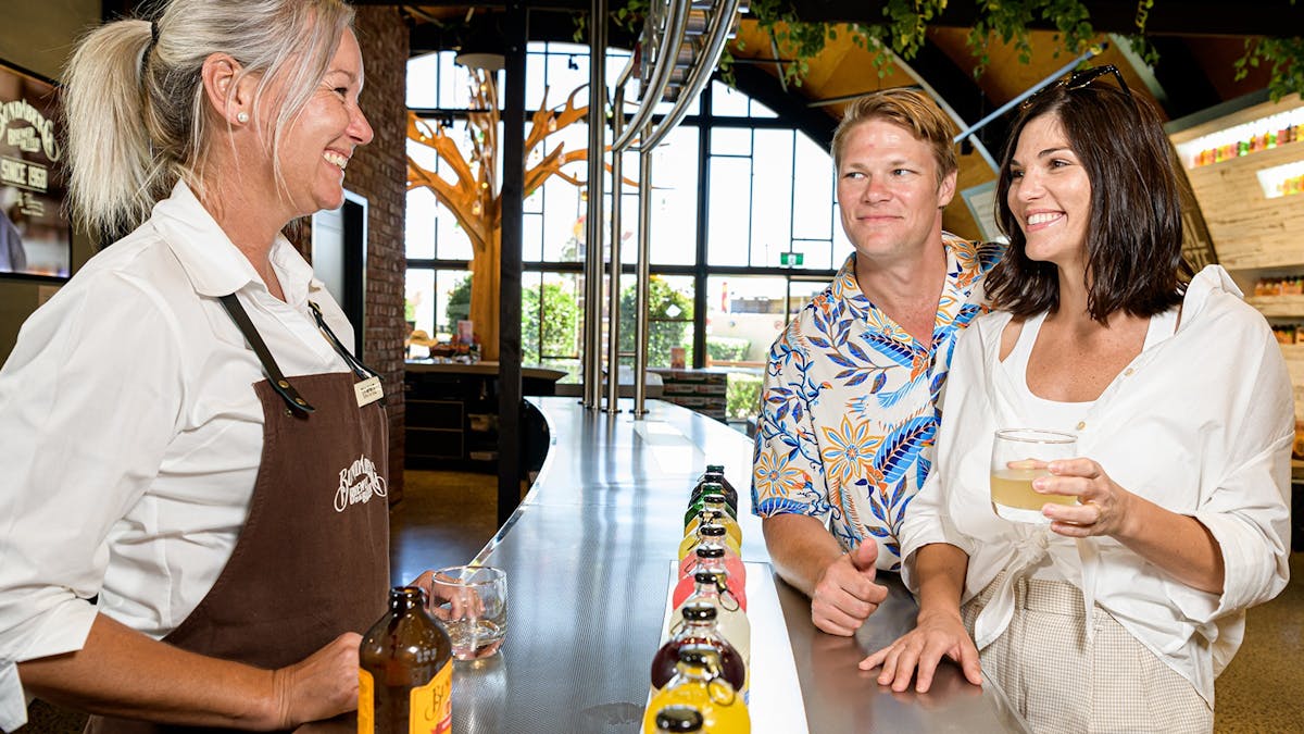 Tour guide and guests sample Bundaberg brews at the tasting bar – cheers all around!