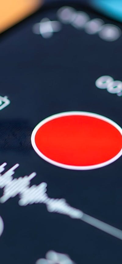 Close-up of a smartphone screen displaying a media player interface with a prominent record button.