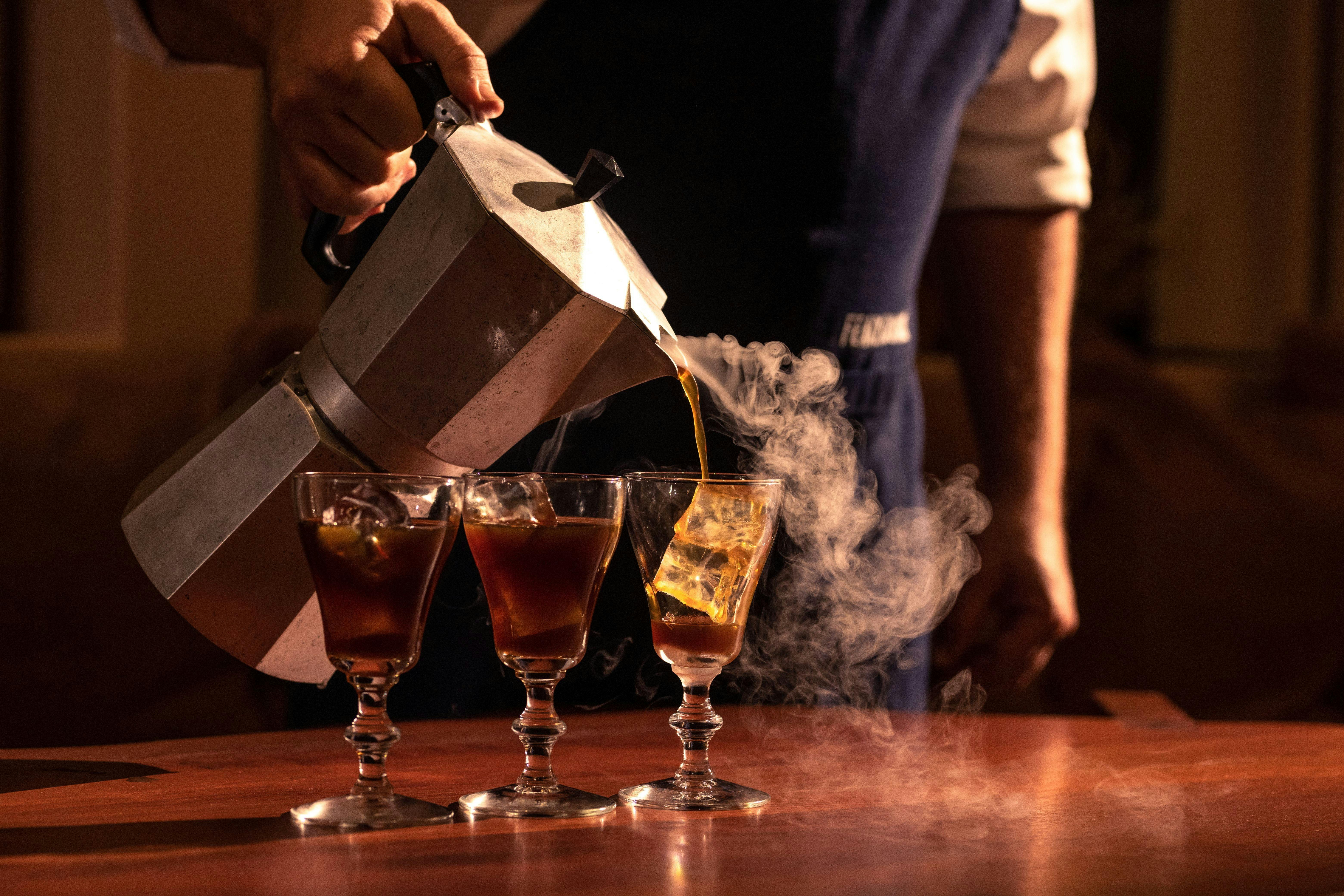 Pouring coffee into elegent glasses by a coffee master.