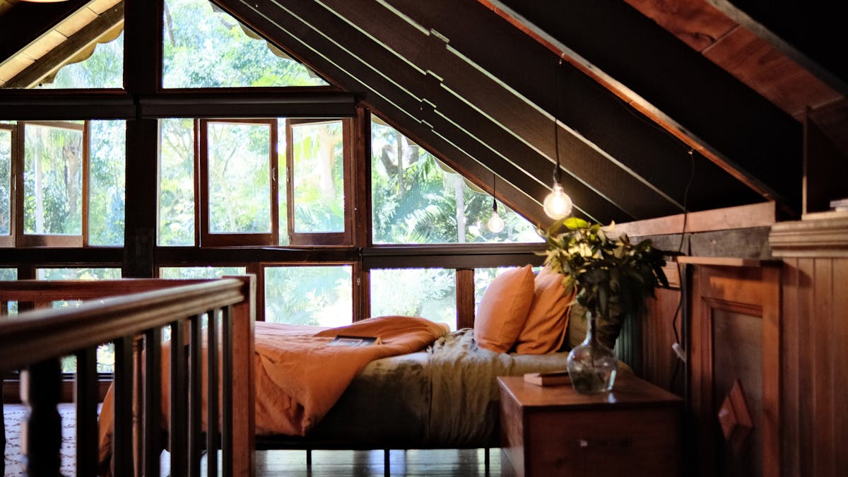 Elm House cabin with open-plan bedroom featuring warm colours and luxury linen.