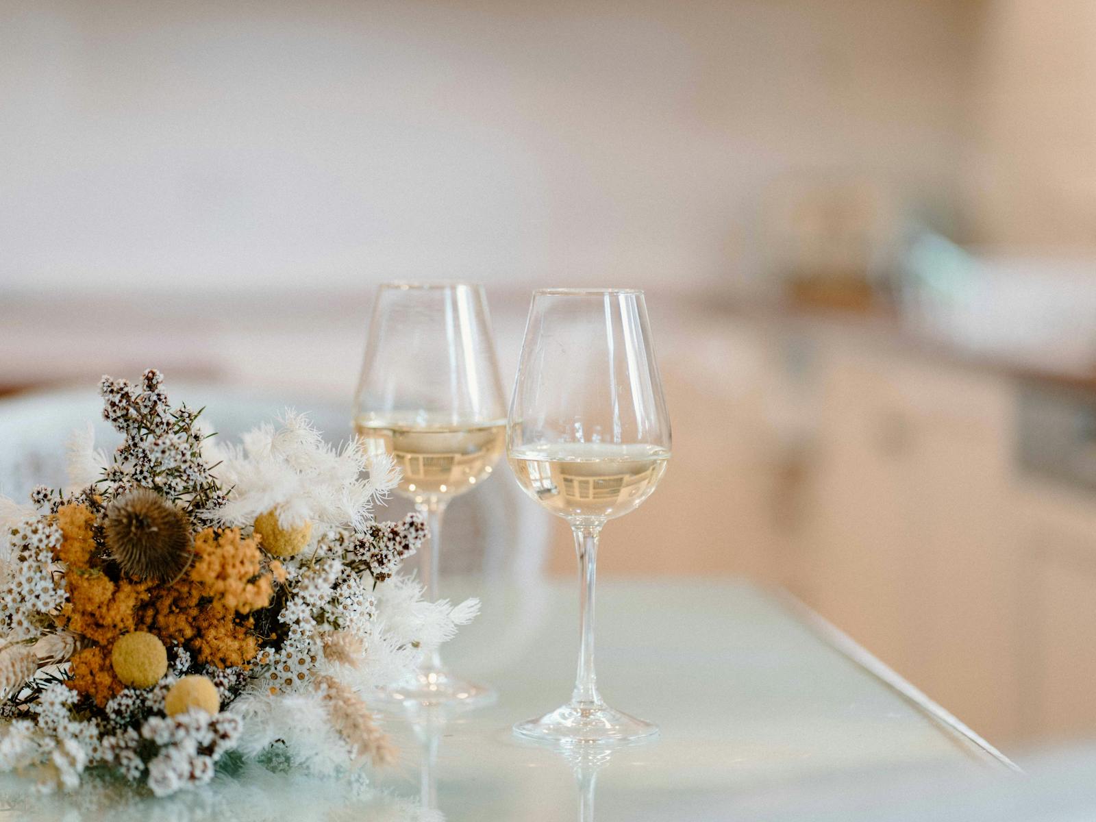 Two glasses of white wine with a bunch of flowers. Enjoy time with friends.