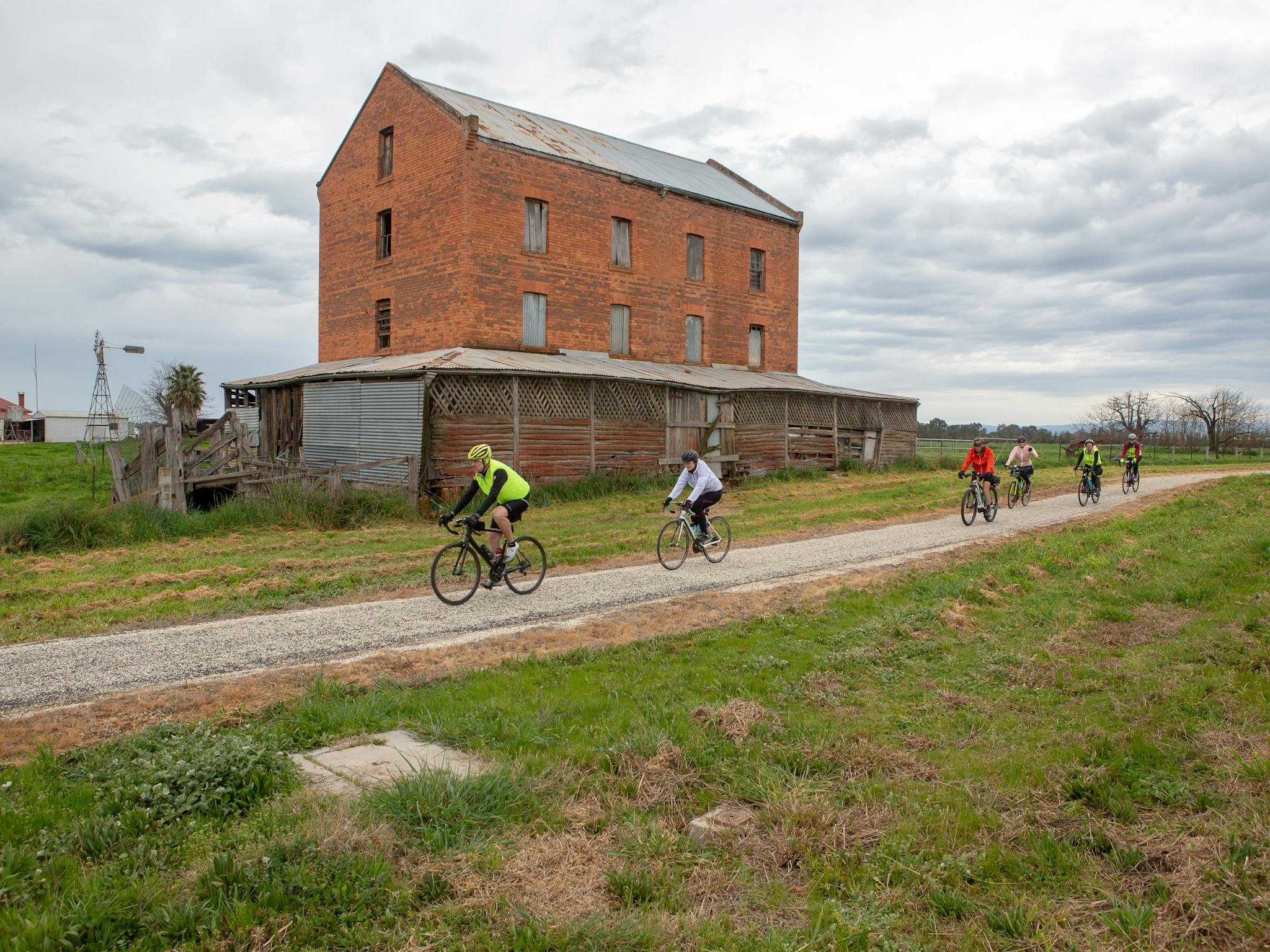 6 cyclists passing the abandoned mill