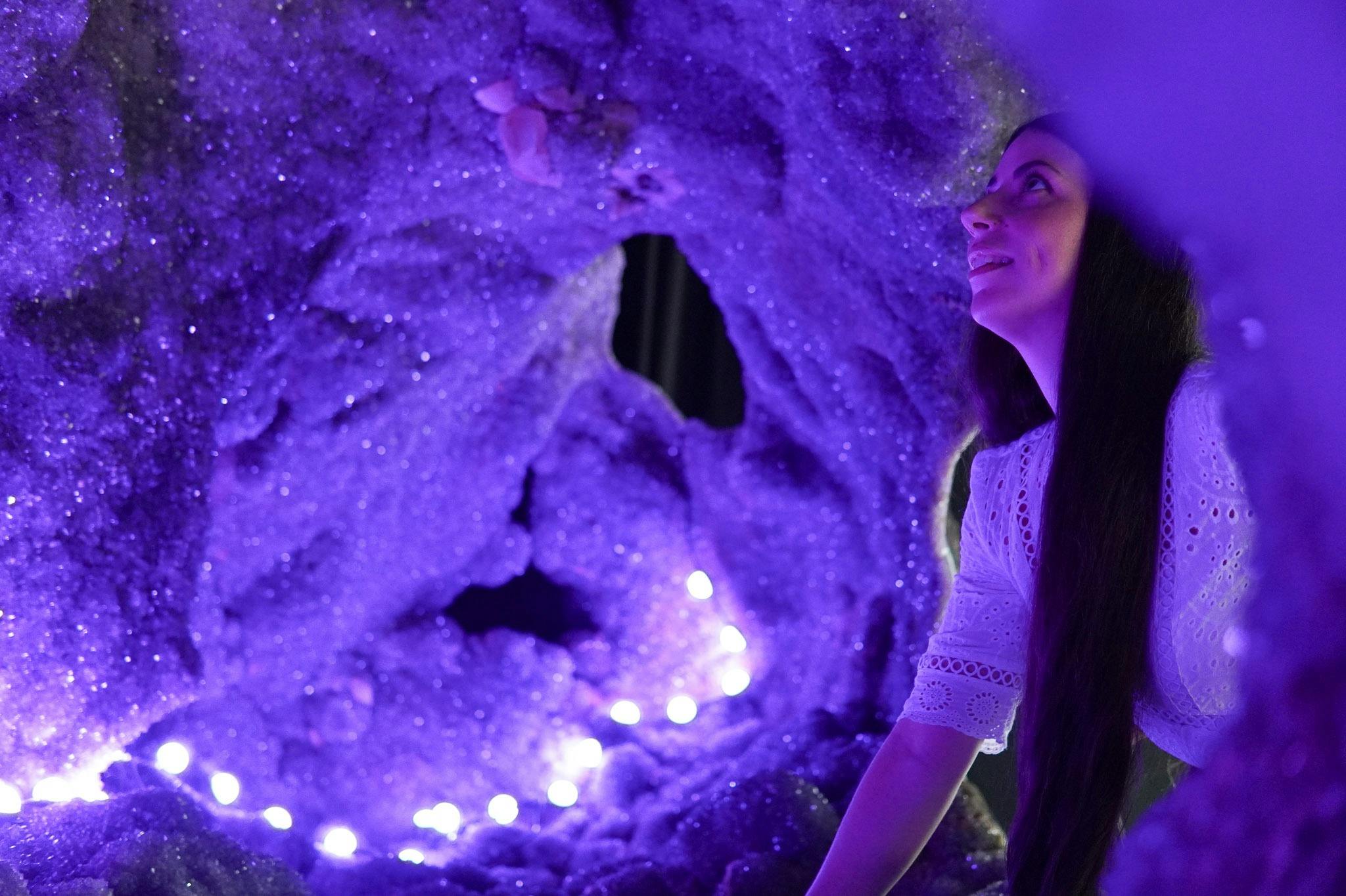 A woman looking inside the Enchanted Cave, the worlds largest amethyst geode weighing 20 tonne