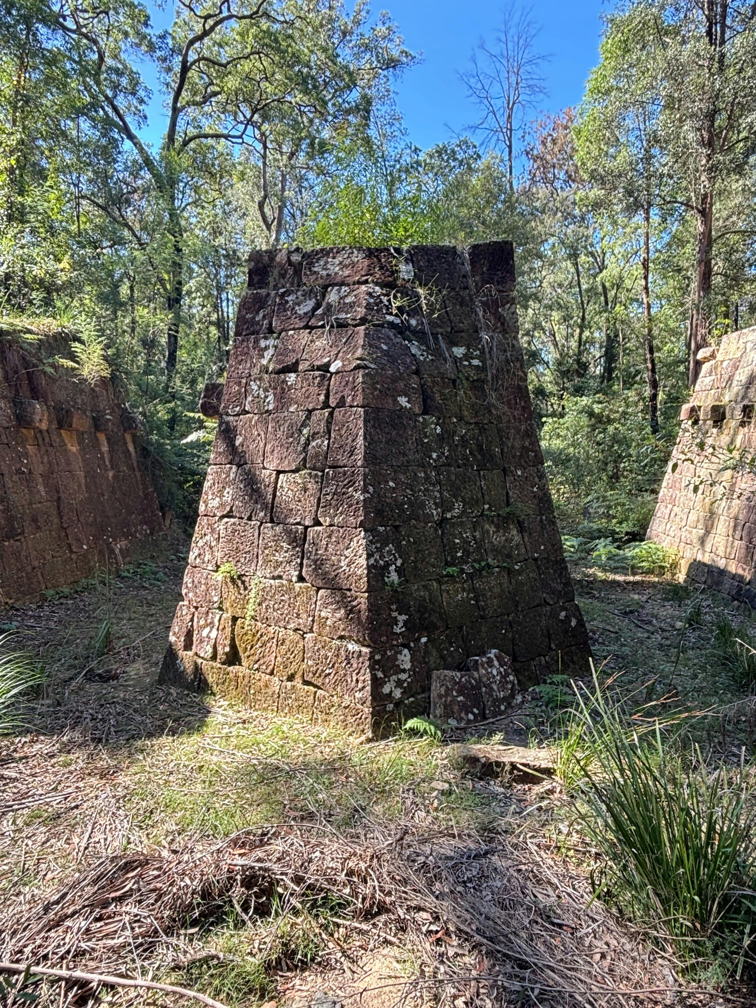 A large stone bridge pier standing in a dry river bed