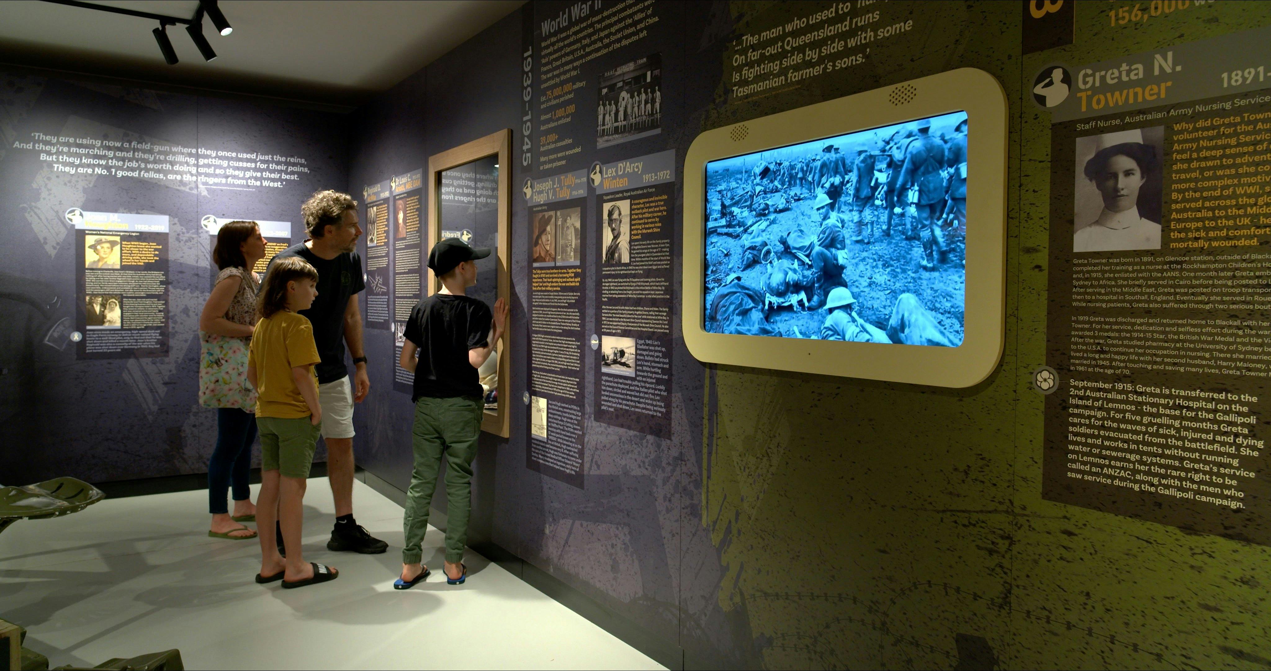 a family of four inside the interactive exhibit looking into a glass display case