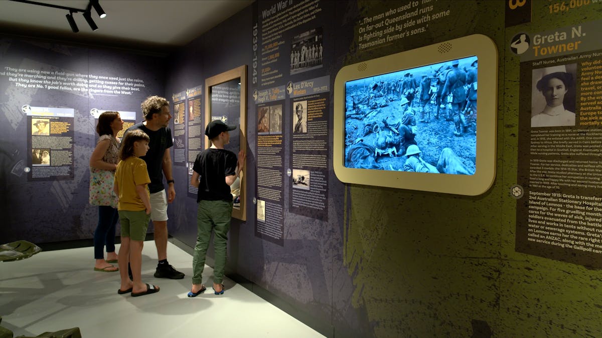a family of four inside the interactive exhibit looking into a glass display case