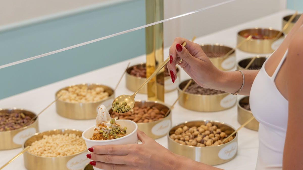 Guest adding toppings to a cup of soft serve gelato at LUMA Gelato