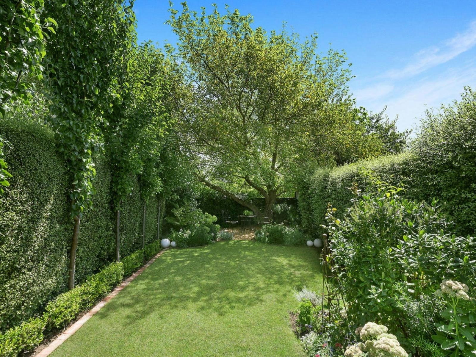 緑豊かな庭園と芝生のある広い裏庭