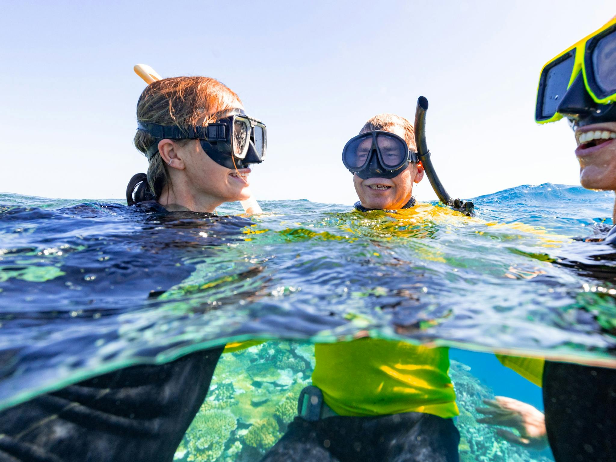 Our Master Reef Guide with two snorkelling guests laughing on the waters surface.. Our Master Reef Guide with two snorkelling guests laughing on the waters surface..