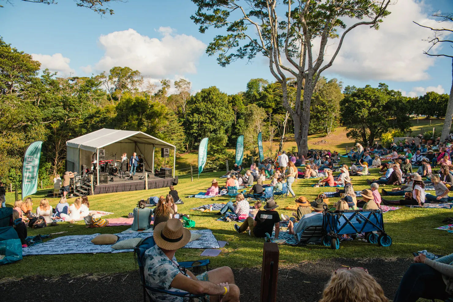 People at the festival with picnic blankets sitting on the lawn
