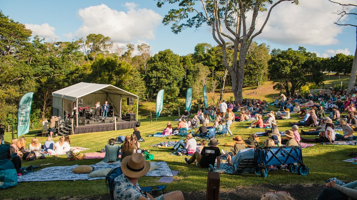 People at the festival with picnic blankets sitting on the lawn