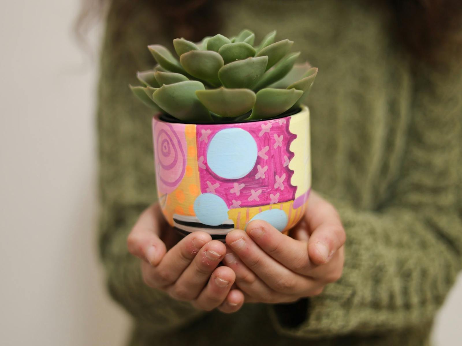 Person holiding a pot they decorated