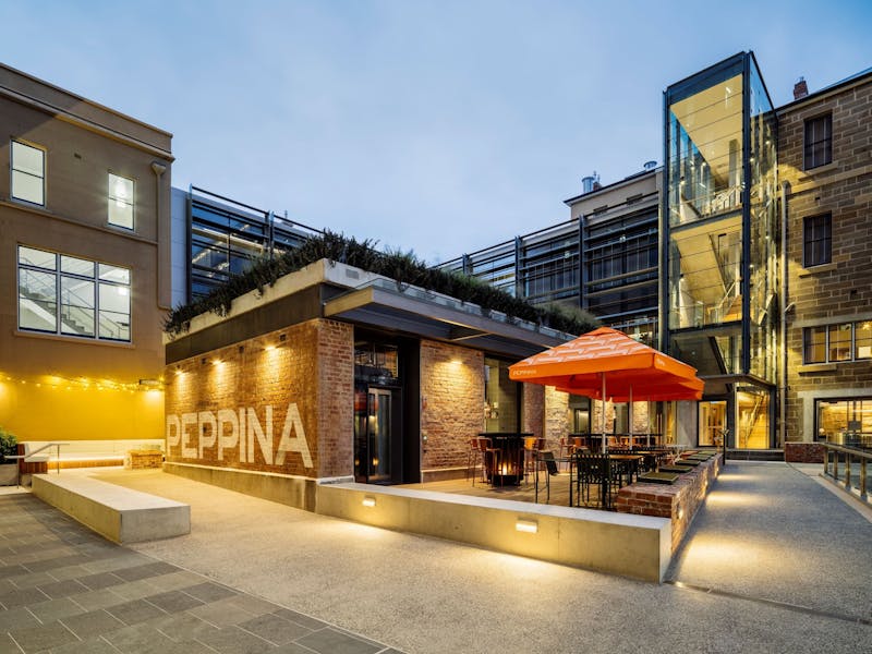 A red brick restaurant with outdoor seating and umbrella