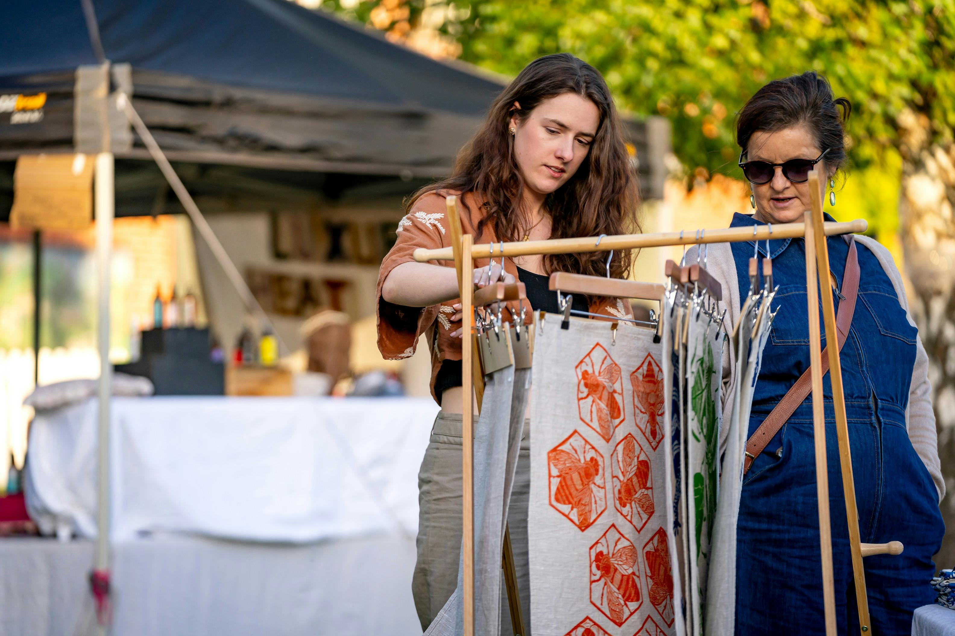 Market goers looking at handmade tea towels at the FABRIK Christmas Market