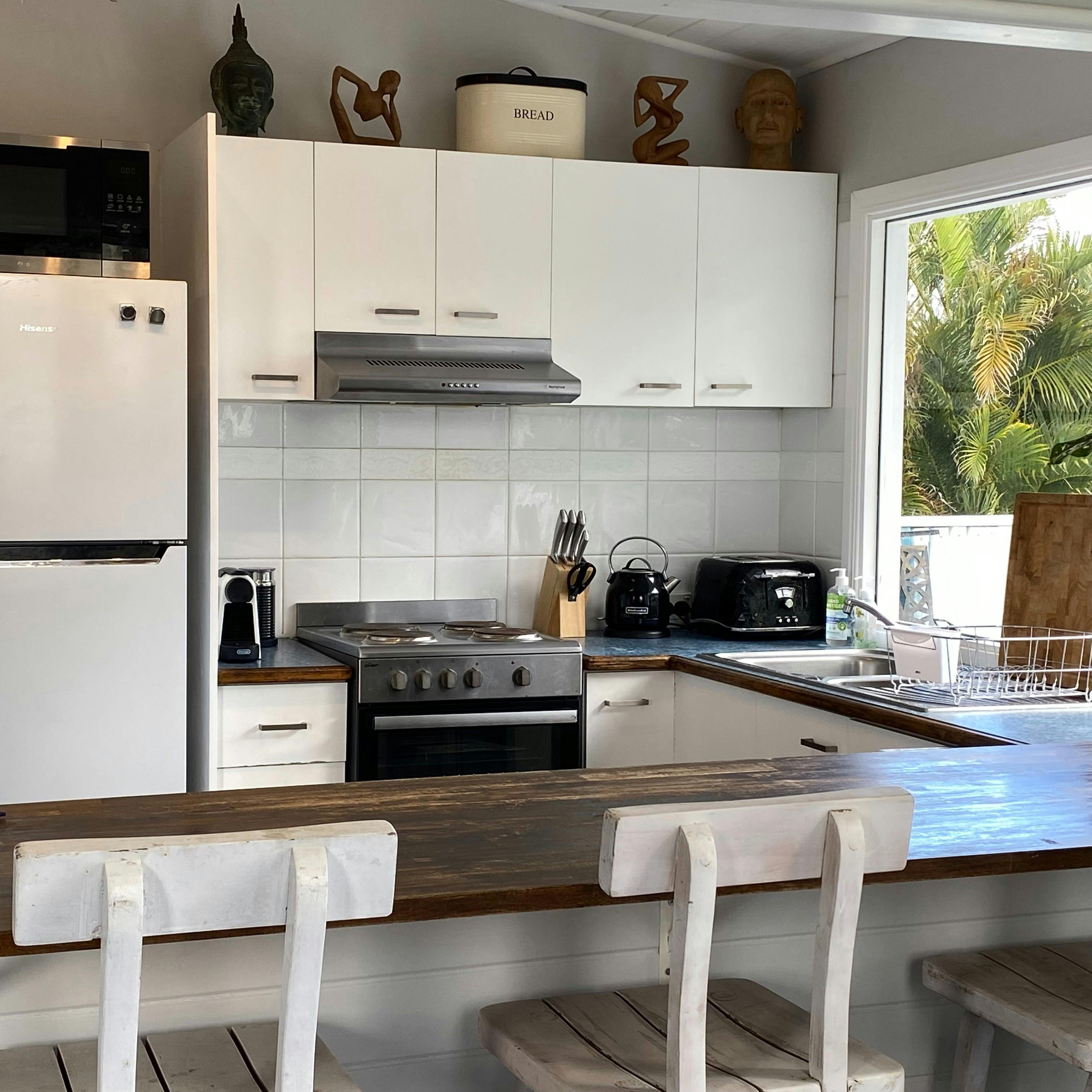 Full kitchen with oven, stove, microwave and dishwasher overlooking the Tweed River