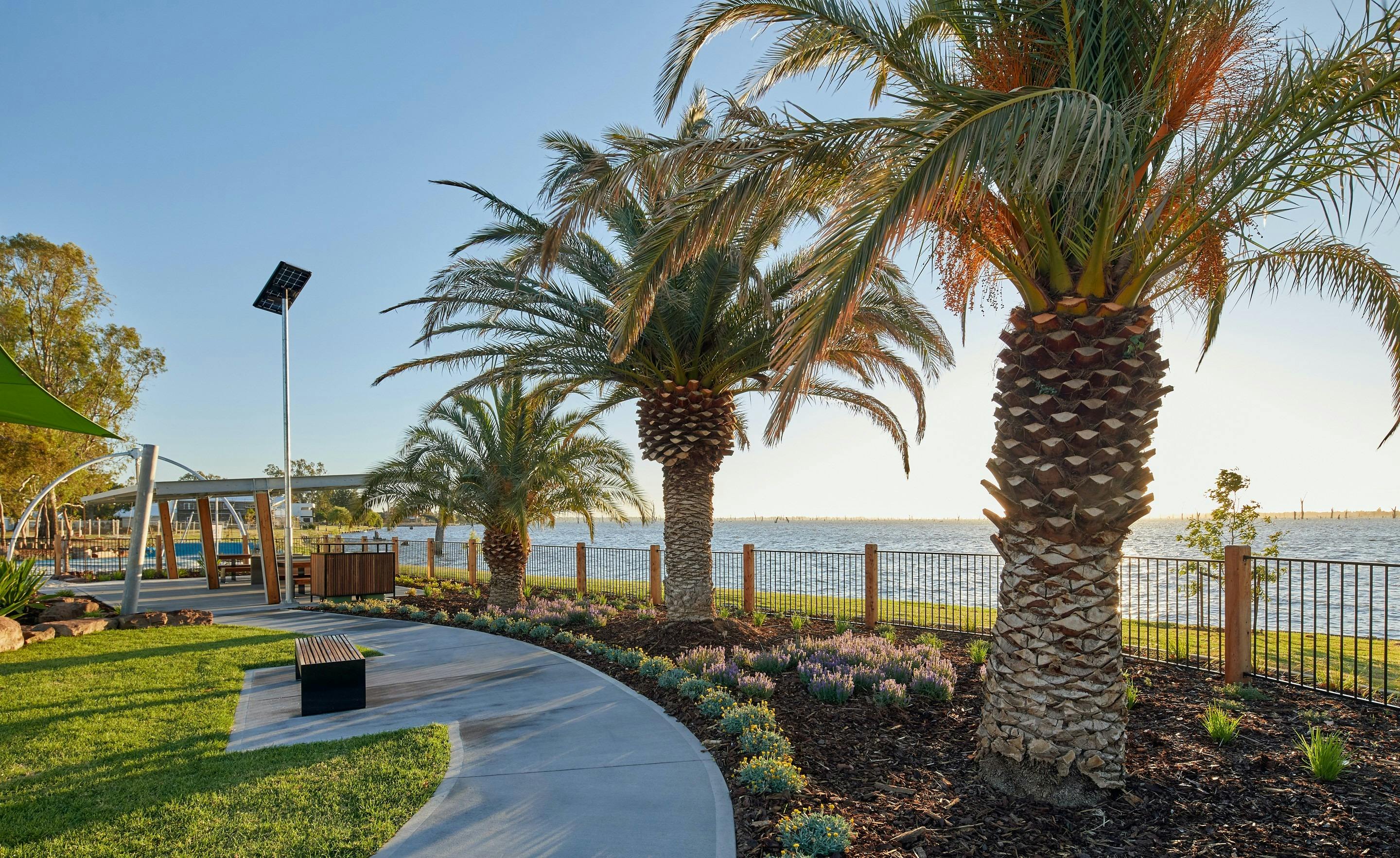 A path winds through an enclosed park on the banks of Lake Mulwala.