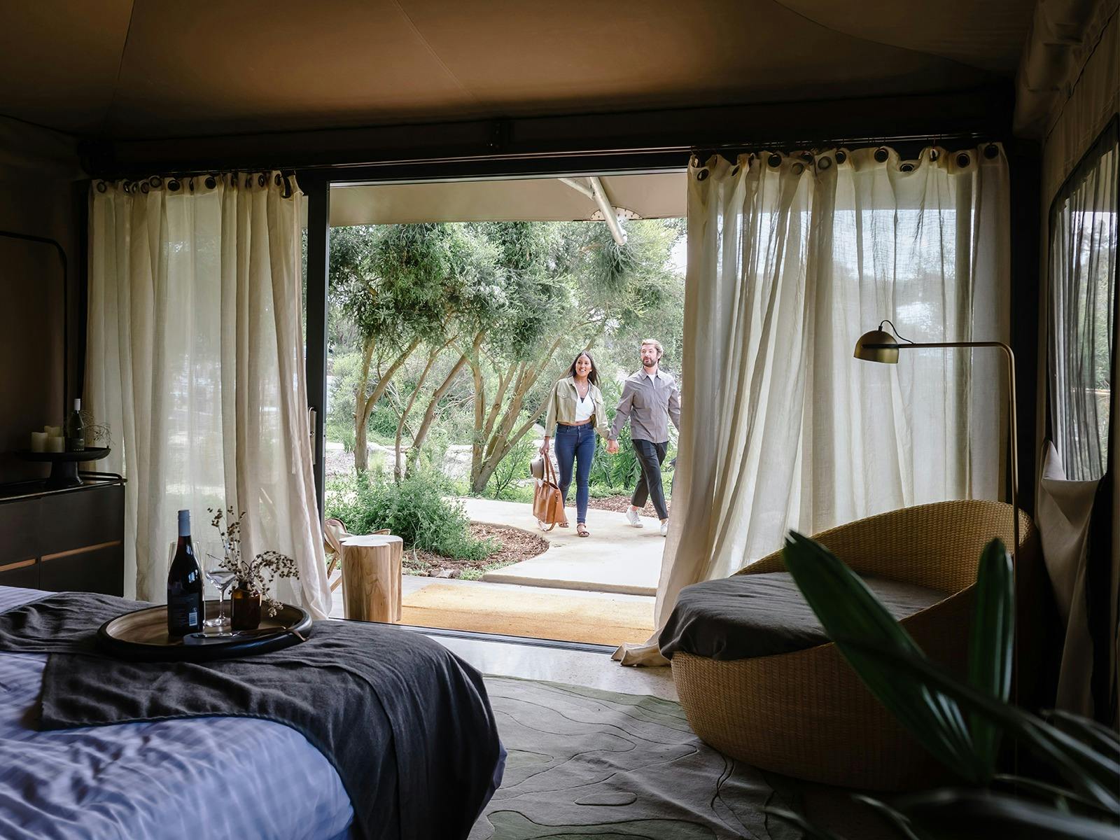 Two people walking into a glamping room