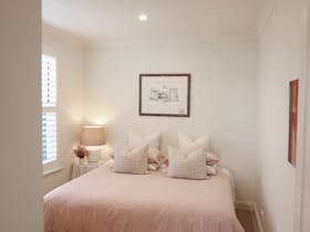 Peaceful guest bedroom with king bed and natural light from window.