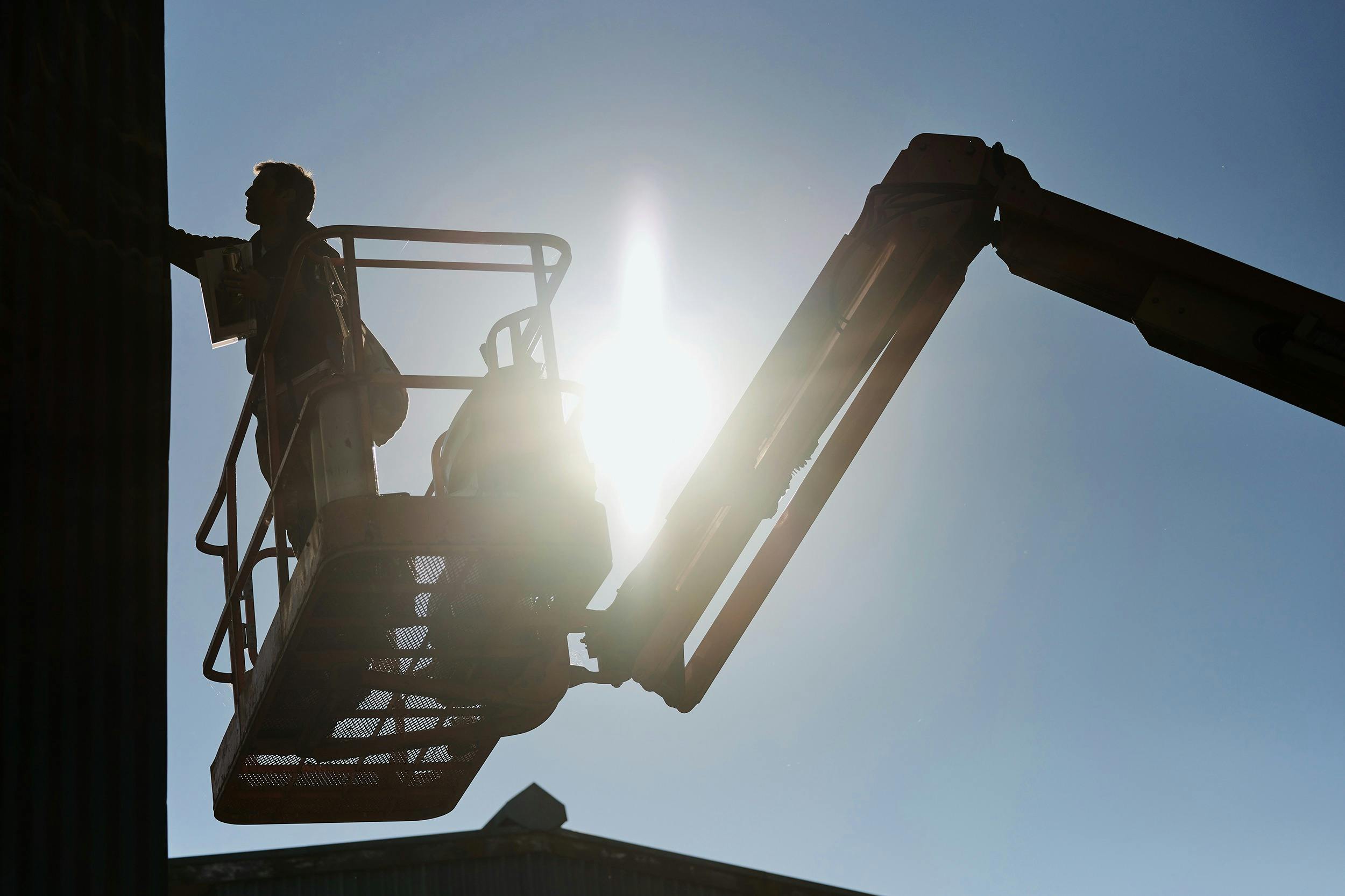 Artist LING on an elevated platform painting a surface