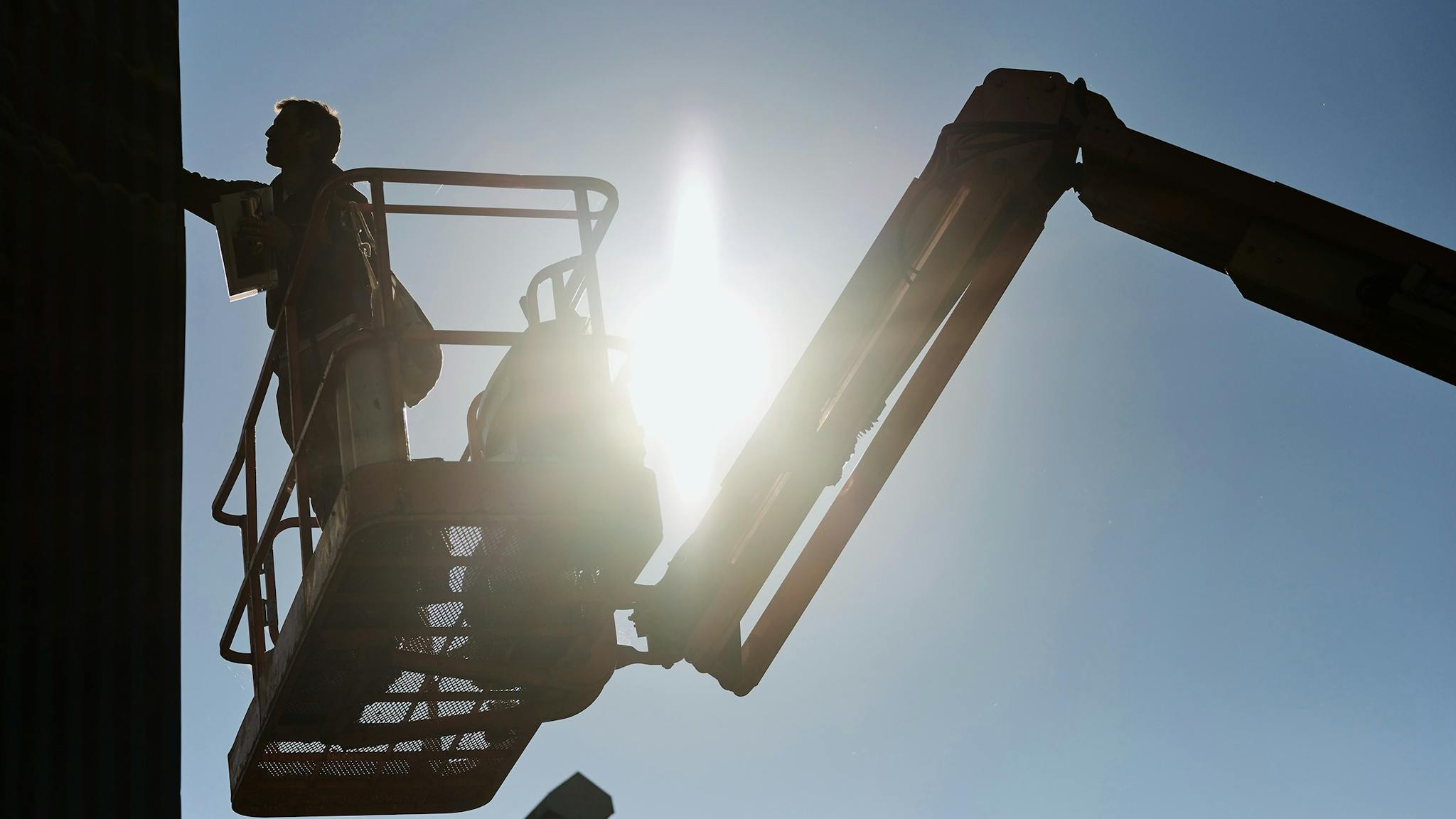 Artist LING on an elevated platform painting a surface