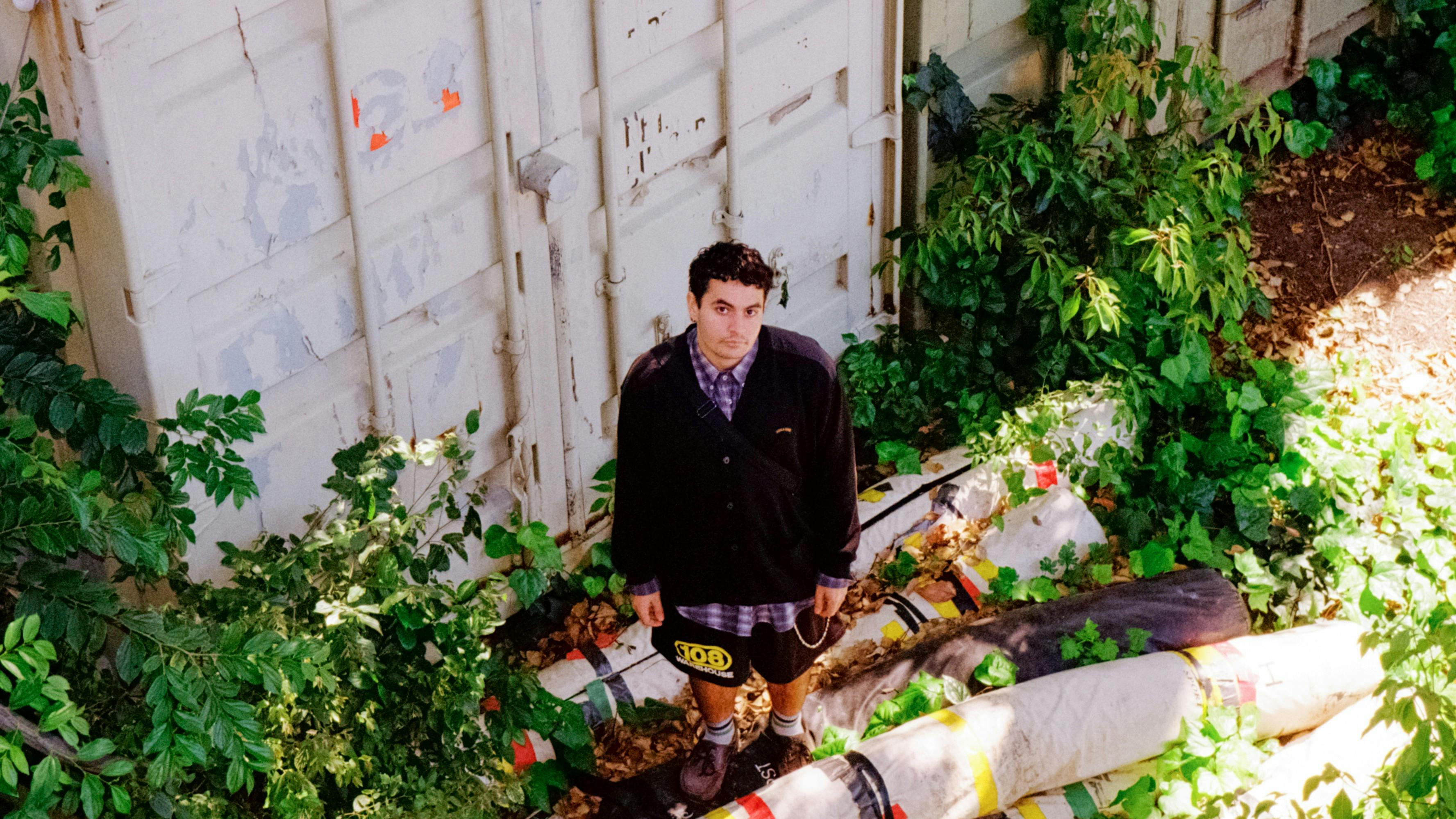 A person standing by an overgrown shipping container
