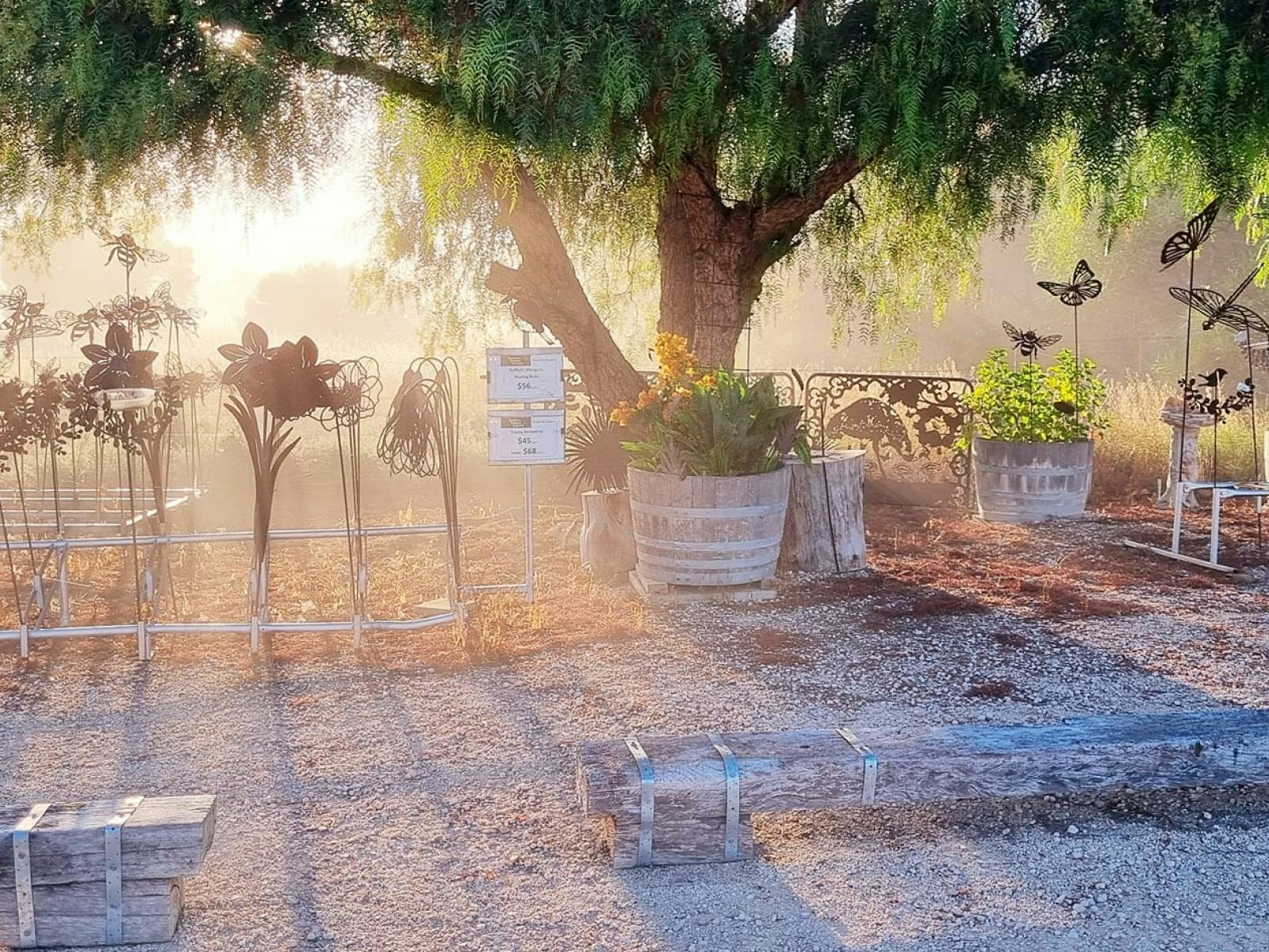 Large 3D Rusty Flowers and insect garden stakes in the morning fog