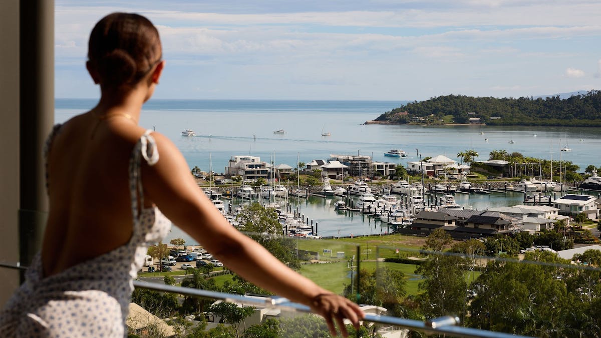 A lady enjoying the stunning ocean and marina views from a balcony
