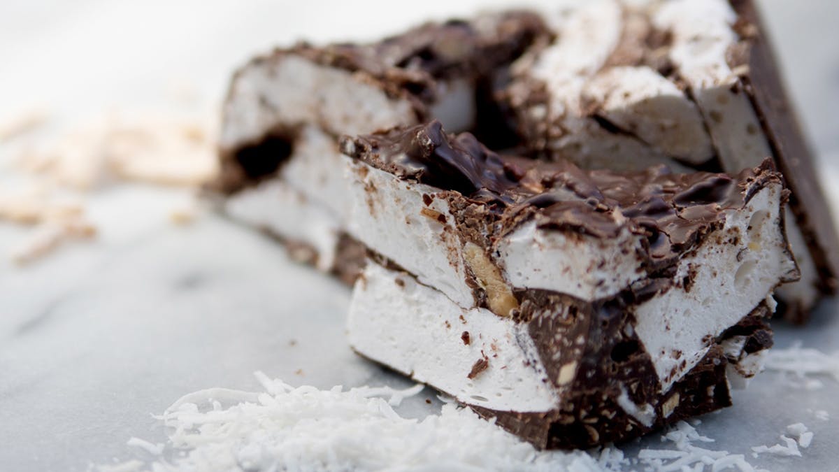 A cross section of marshmallows, dark chocolate with scattered ingredients